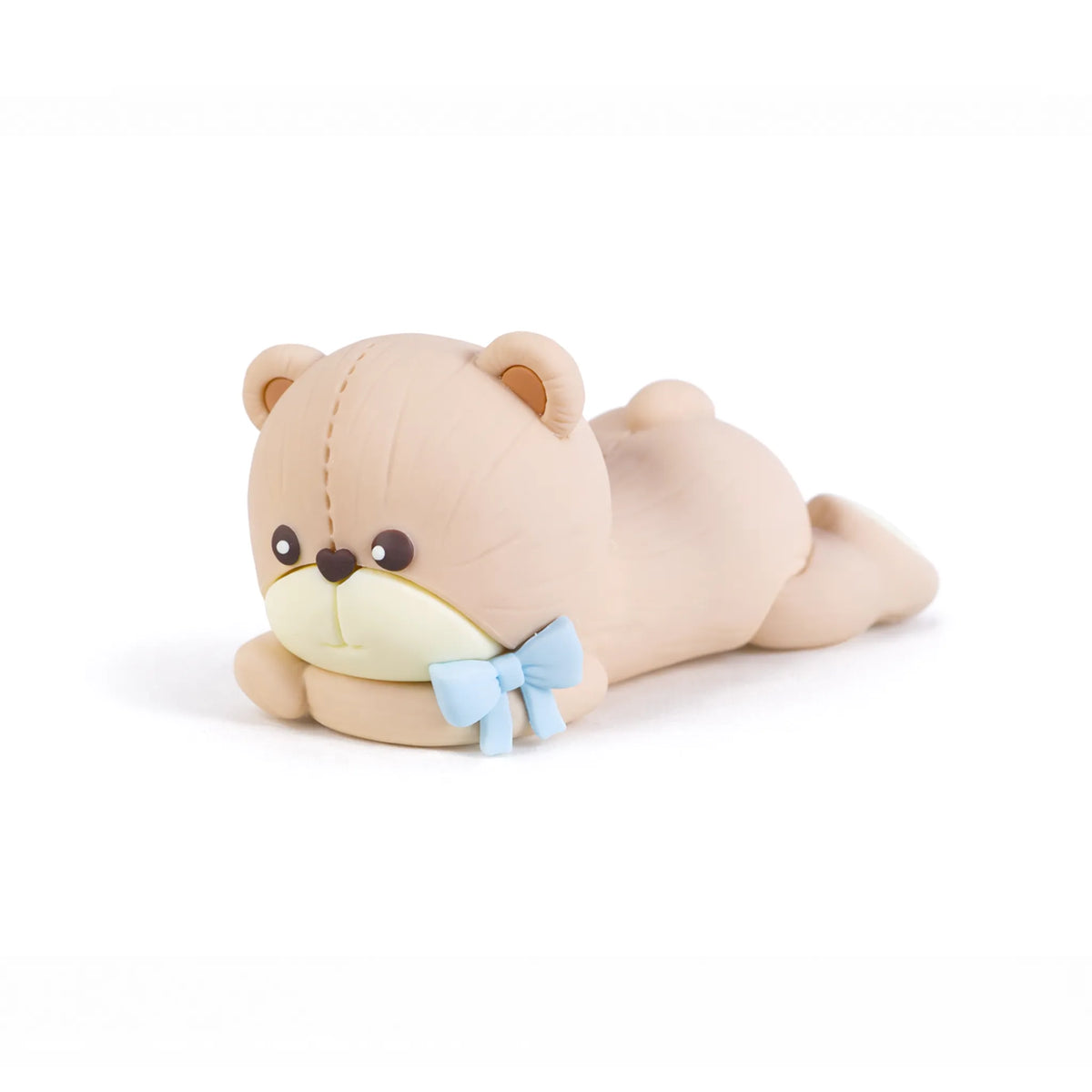 Blue bow teddy bear laying on stomach cake topper